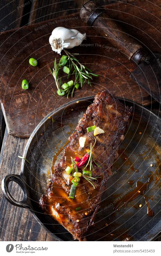 Marinated and grilled spare ribs with Barbecue sauce in roasting tray wooden board wooden boards wooden panel wooden panels Garlic spring onion spring onions