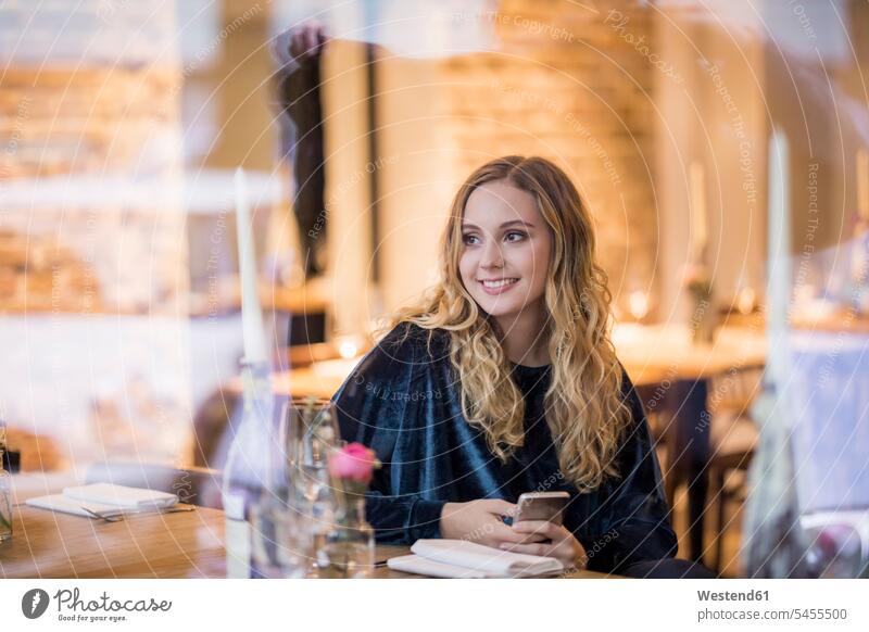Portrait of smiling young woman waiting in a restaurant portrait portraits restaurants smile females women Adults grown-ups grownups adult people persons