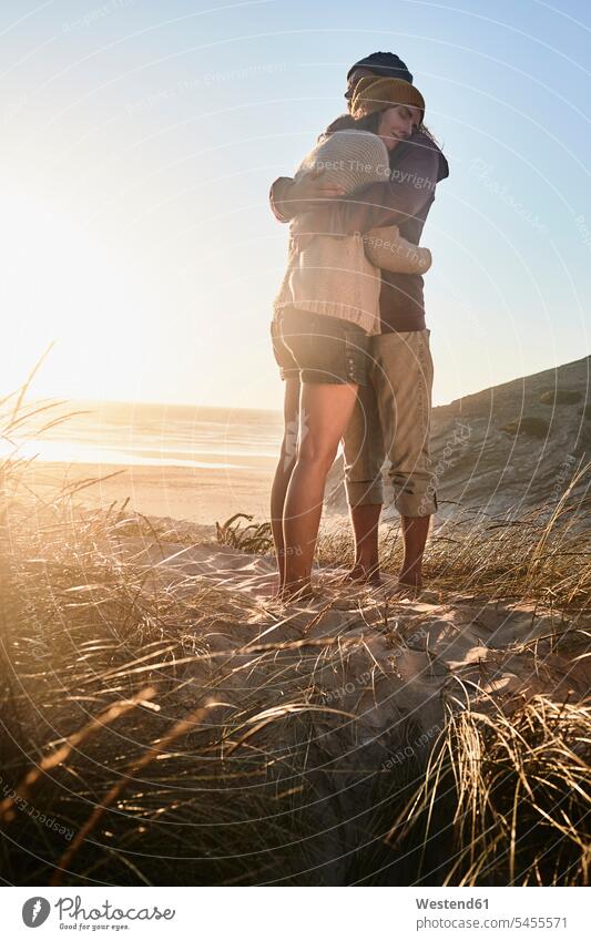 Portugal, Algarve, couple hugging at sunset on the beach beaches twosomes partnership couples embracing embrace Embracement people persons human being humans