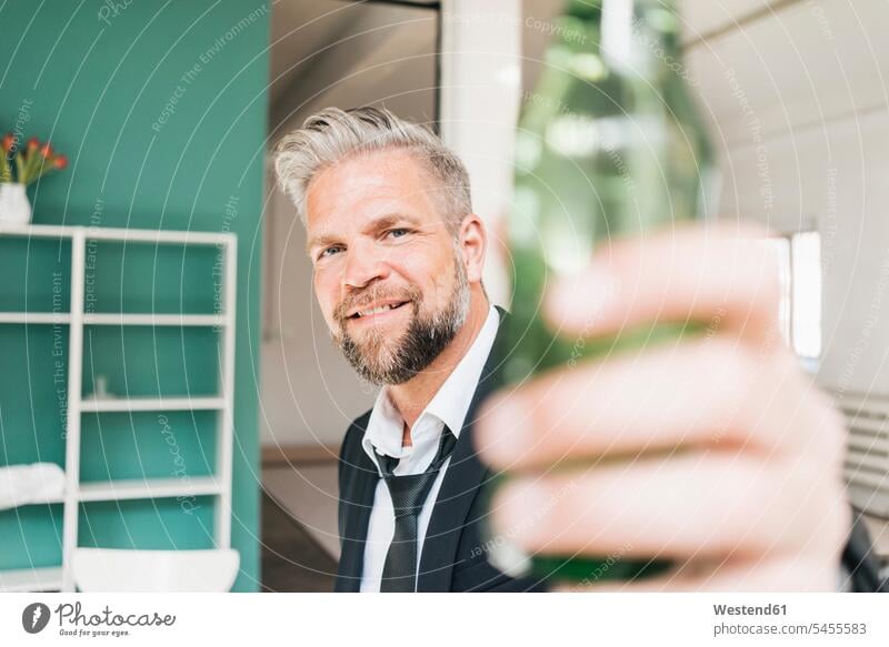 Businessman toasting with bottle of beer Office Offices clinking cheers Business man Businessmen Business men business people businesspeople business world