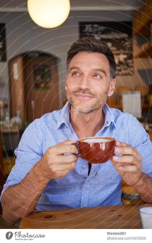Portrait of smiling man with cup of coffee in a coffee shop men males Coffee Coffee Cup Coffee Cups portrait portraits cafe smile Adults grown-ups grownups