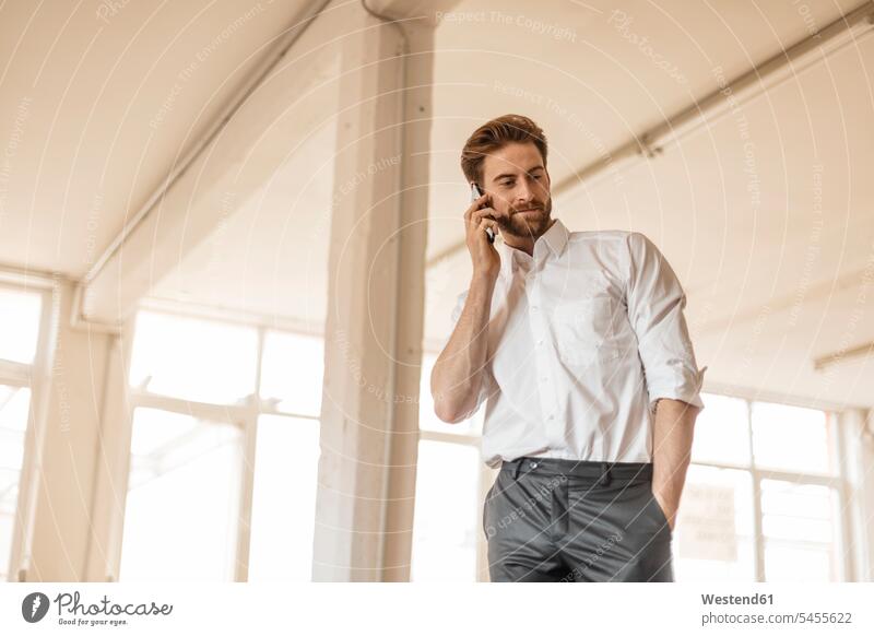 Portrait of young businessman on the phone in a loft call telephoning On The Telephone calling Businessman Business man Businessmen Business men telephone call