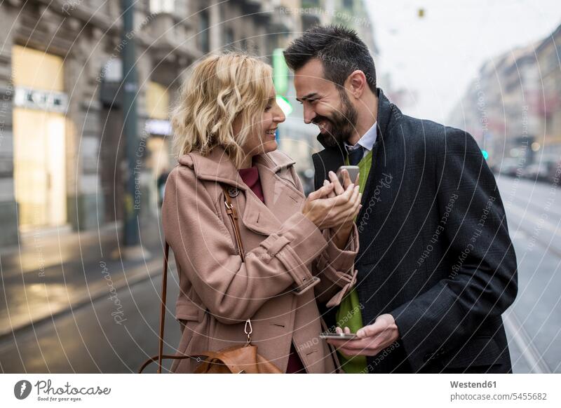 Happy business couple with cell phones in the city smiling smile businesswoman businesswomen business woman business women happiness happy mobile phone mobiles