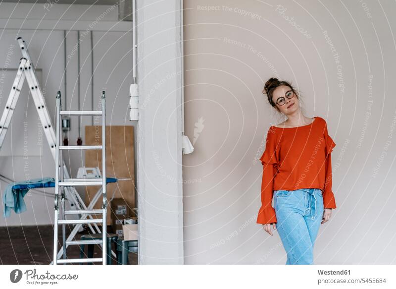 Portrait of young woman in a room with a ladder standing females women Adults grown-ups grownups adult people persons human being humans human beings glasses