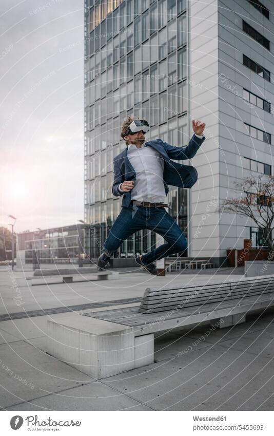 Businessman wearing VR glasses jumping in the city specs Eye Glasses spectacles Eyeglasses Business man Businessmen Business men Leaping virtual reality town