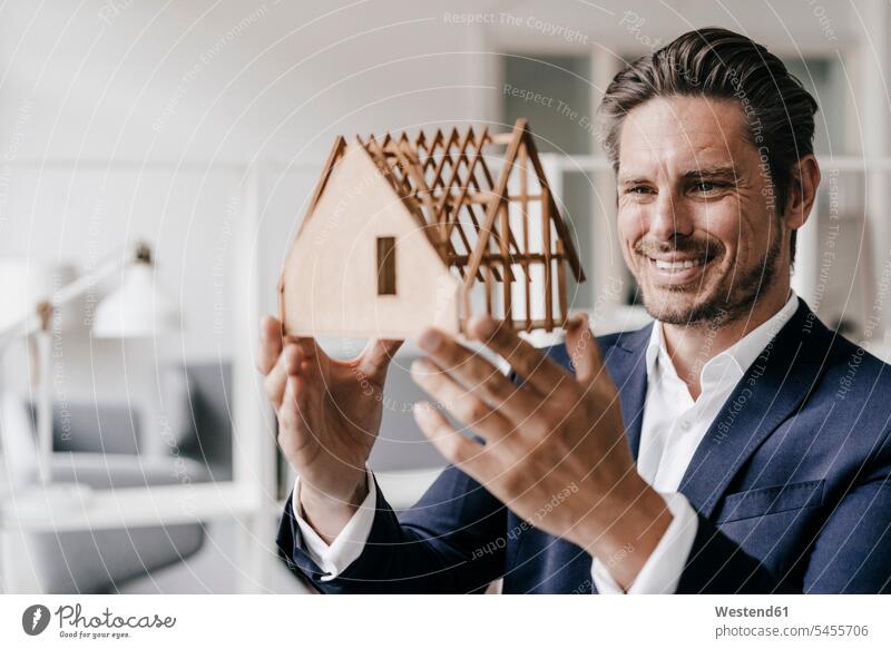 Smiling architect examining architectural model models smiling smile man men males looking eyeing architects Adults grown-ups grownups adult people persons