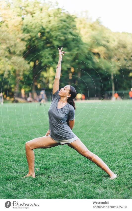 Young woman doing yoga exercise in a park females women mindfulness aware awareness self-care relaxation exercise relaxed relaxing Adults grown-ups grownups