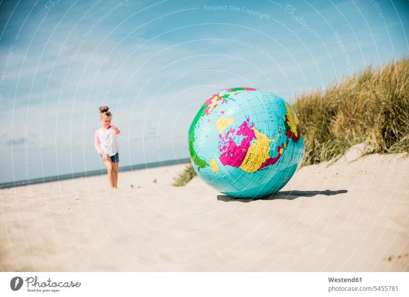 Globe on the beach with girl in background females girls beaches globe globes child children kid kids people persons human being humans human beings beach dune