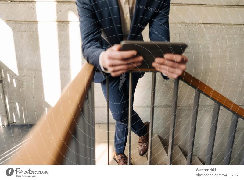 Businessman holding tablet in staircase Business man Businessmen Business men stairs stairway digitizer Tablet Computer Tablet PC Tablet Computers iPad