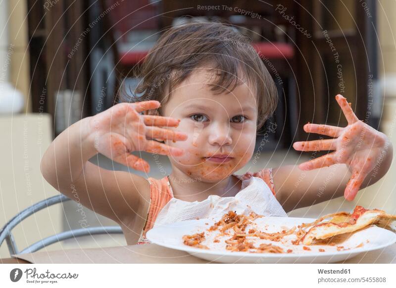 Portrait of little girl eating spaghetti with fingers females girls portrait portraits child children kid kids people persons human being humans human beings