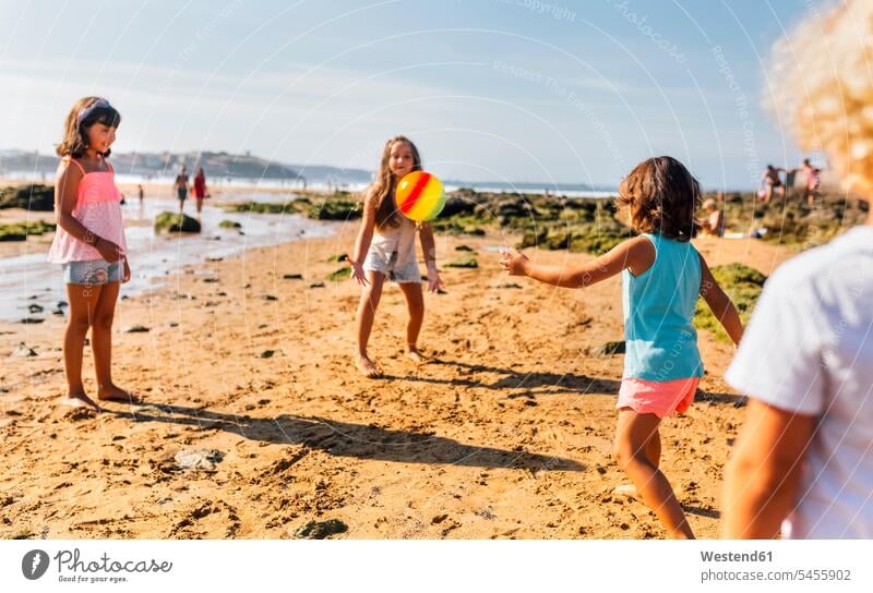 Group of children playing on the beach with ball beaches friends friendship kid kids balls people persons human being humans human beings four people 4 mid-air