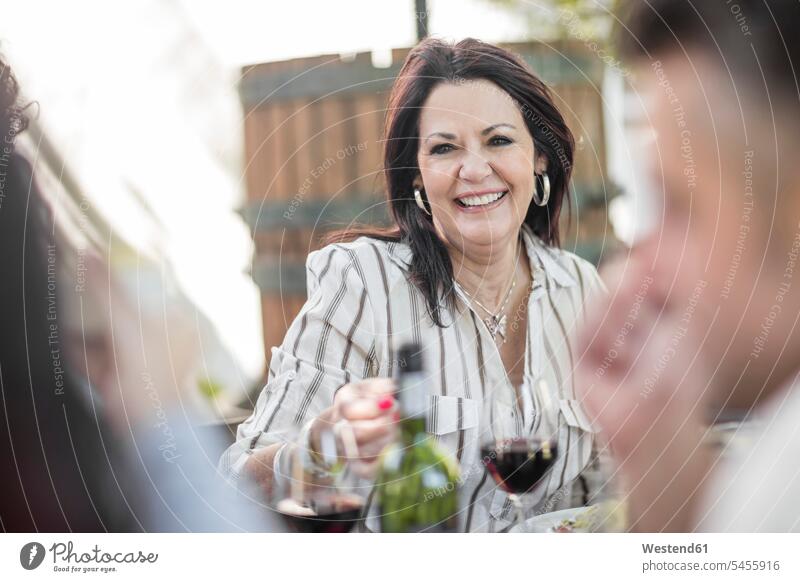 Smiling senior woman at family lunch in garden Wine friends Red Wine Red Wines smiling smile celebrating celebrate partying group of people Group