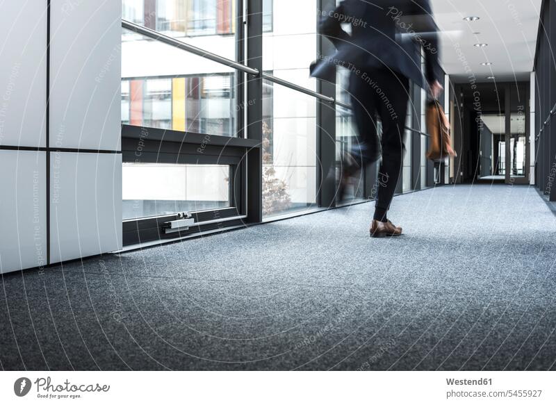 Businessman running in corridor of an office building hallway corridors hallways fast quick speediness rapidity rapidness apace Hurry rushing Urgency urgent