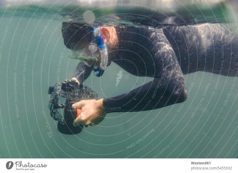 Man diving with underwater DSLR camera case dive man men males cameras diver divers Adults grown-ups grownups adult people persons human being humans