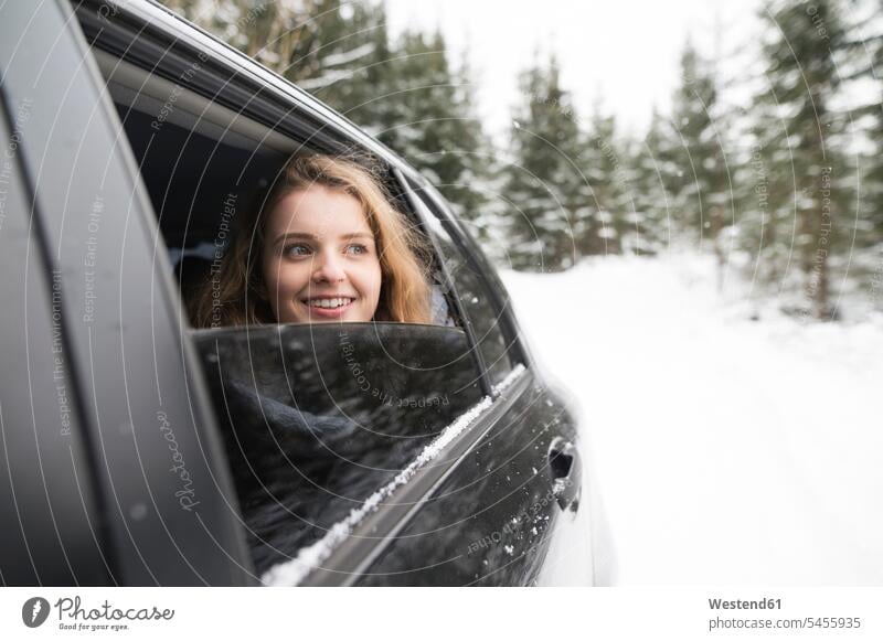 Young woman looking out of a car window in winter landscape portrait portraits car windows females women Adults grown-ups grownups adult people persons