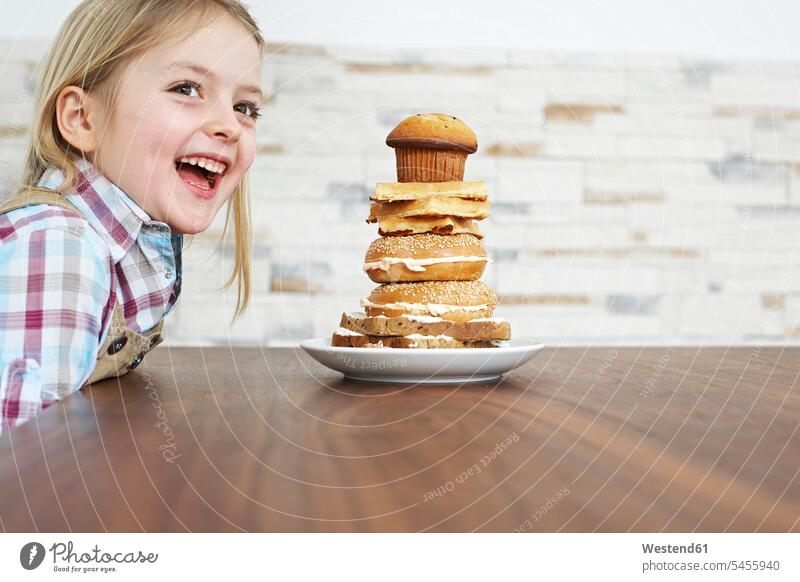 Portrait of smiling little girl with stack of baked goods females girls portrait portraits child children kid kids people persons human being humans