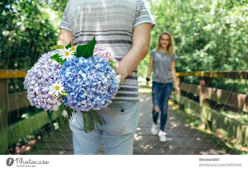 Man holding a bouquet of hydrangeas behind his back to surprise his girlfriend Bunch of Flowers Bouquet Flower Bouquet Bouquet of Flowers Flower Bouquets
