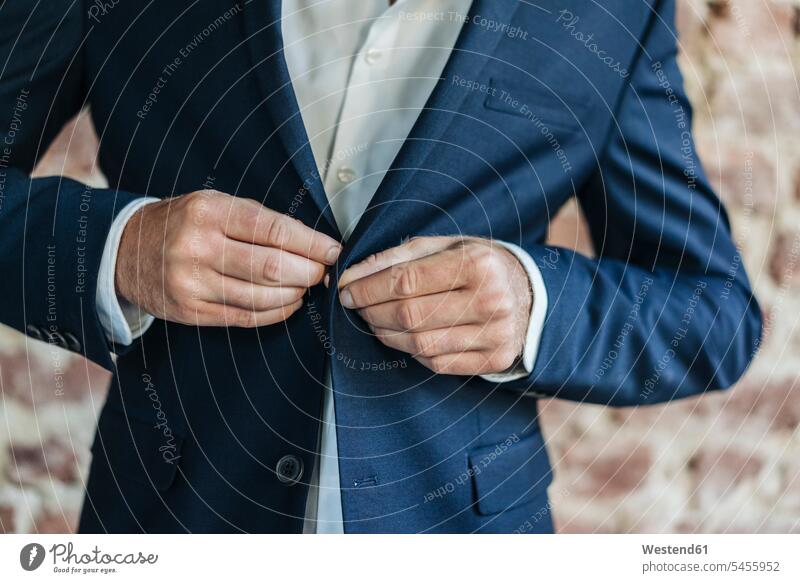Close-up of of businessman buttoning jacket buttons Businessman Business man Businessmen Business men Buttoning business people businesspeople business world