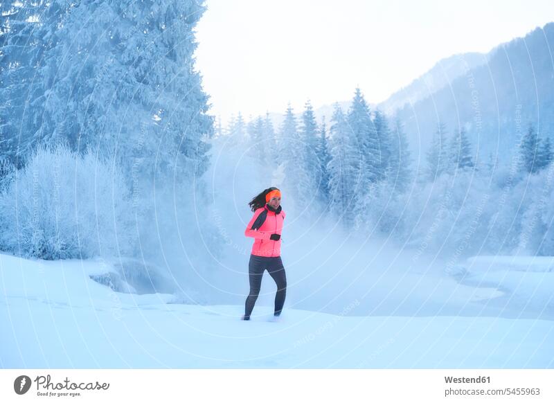 Germany, Bavaria, Isar valley, Vorderriss, woman jogging in winter exercising exercise training practising running Jogging females women fitness sport sports