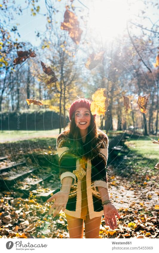 Portrait of a beautiful happy woman having fun with leaves in an autumnal forest woods forests happiness Leaf Leaves females women portrait portraits Fun funny
