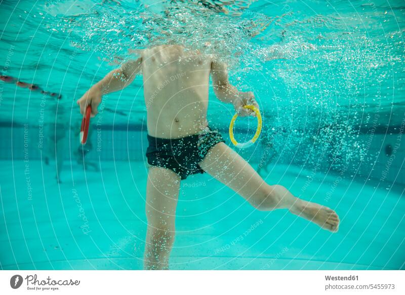 Boy holding two diving rings under water in swimming pool swimming bath boy boys males underwater submerged Under Water underwater shot underwater shots child