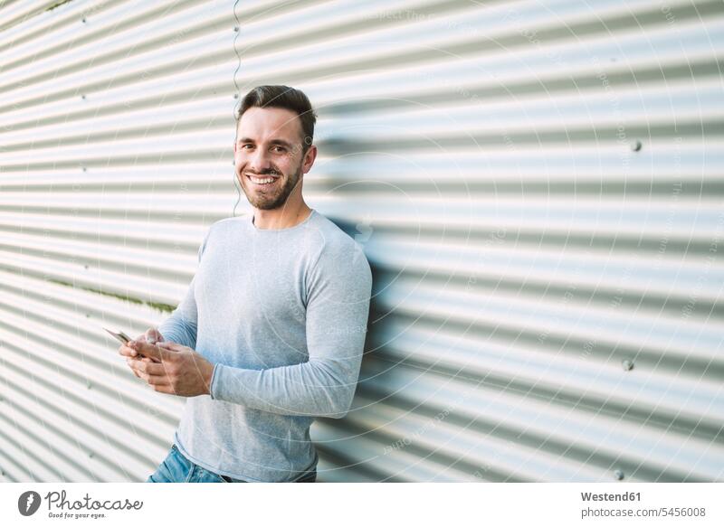 Portrait of laughing man with smartphone Laughter portrait portraits men males Smartphone iPhone Smartphones positive Emotion Feeling Feelings Sentiments
