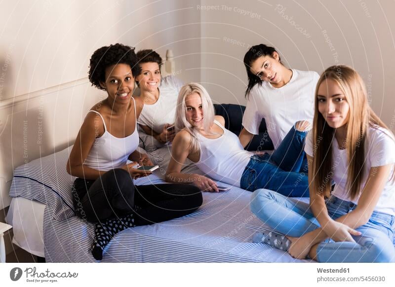 Portrait of female friends with cell phones in bedroom home at home Domestic Bedroom happiness happy beds mobile phone mobiles mobile phones Cellphone portrait