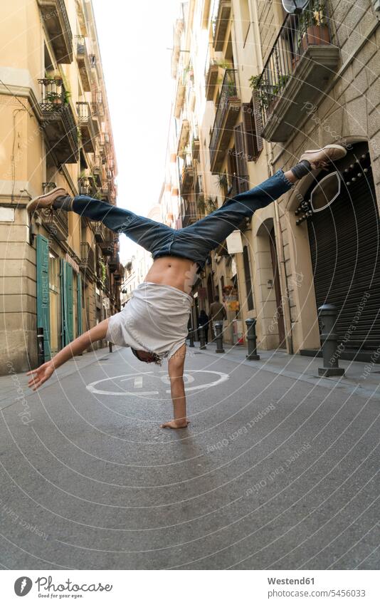 Young man doing a handstand in the city town cities towns men males handstands outdoors outdoor shots location shot location shots Adults grown-ups grownups
