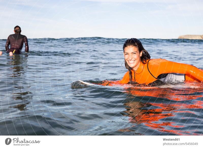 Two surfers in the water surfboard surfboards smiling smile sea ocean surfing surf ride surf riding Surfboarding water sports Water Sport aquatics waters