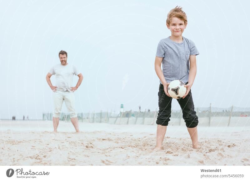 Portrait of smiling little boy playing with his father on the beach pa fathers daddy dads papa beaches son sons manchild manchildren parents family families