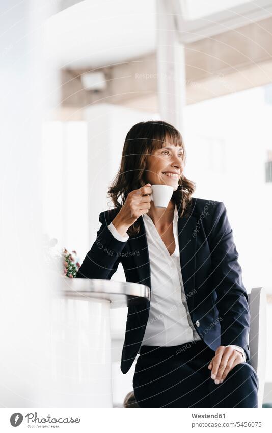 Businesswoman sitting in cafe, drinking coffee counter smiling smile businesswoman businesswomen business woman business women Coffee Seated business people