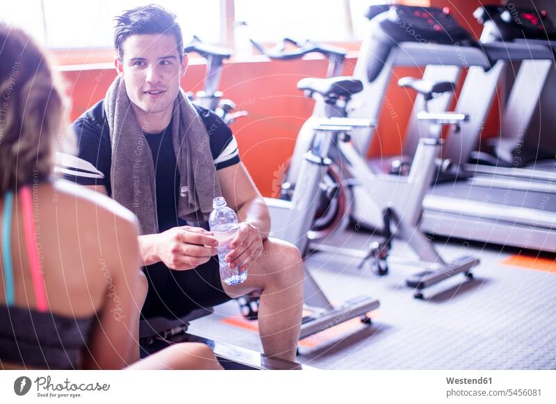 Young man and woman having a refreshment break in gym exercising exercise training practising gyms Health Club fitness sport sports Fitness Water