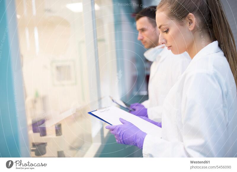 Man and woman in lab coats with clipboards females women Laboratory Coat Labcoats Lab Coat Laboratory Coats Lab Coats laboratory clip-board clip-boards