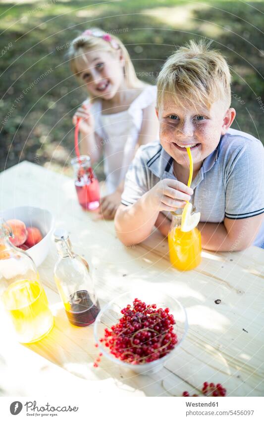 Sister and brother drinking homemade lemonade at garden table brothers smiling smile Lemonade sister sisters siblings brother and sister brothers and sisters