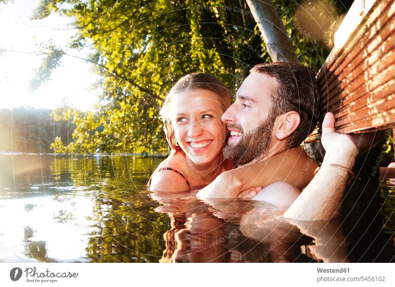 Happy young couple in a lake lakes twosomes partnership couples swimming happiness happy water waters body of water people persons human being humans