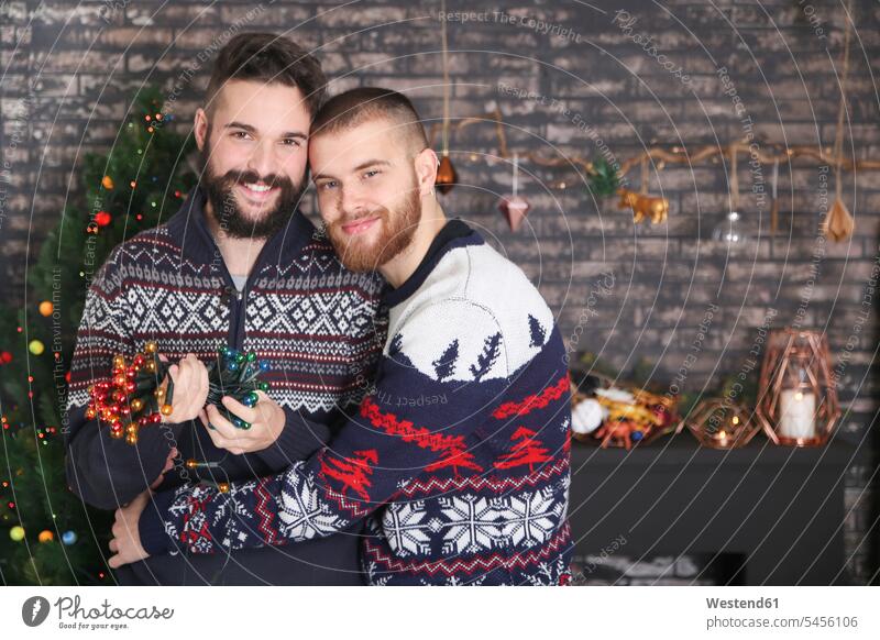 Portrait of happy gay couple with chain of lights at Christmas time Gay Couple Gays portrait portraits same-sex couple woman and woman women and women