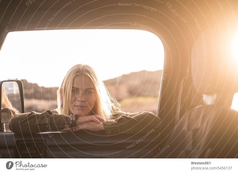 Portrait of young woman leaning on car window looking inside females women portrait portraits automobile Auto cars motorcars Automobiles Adults grown-ups
