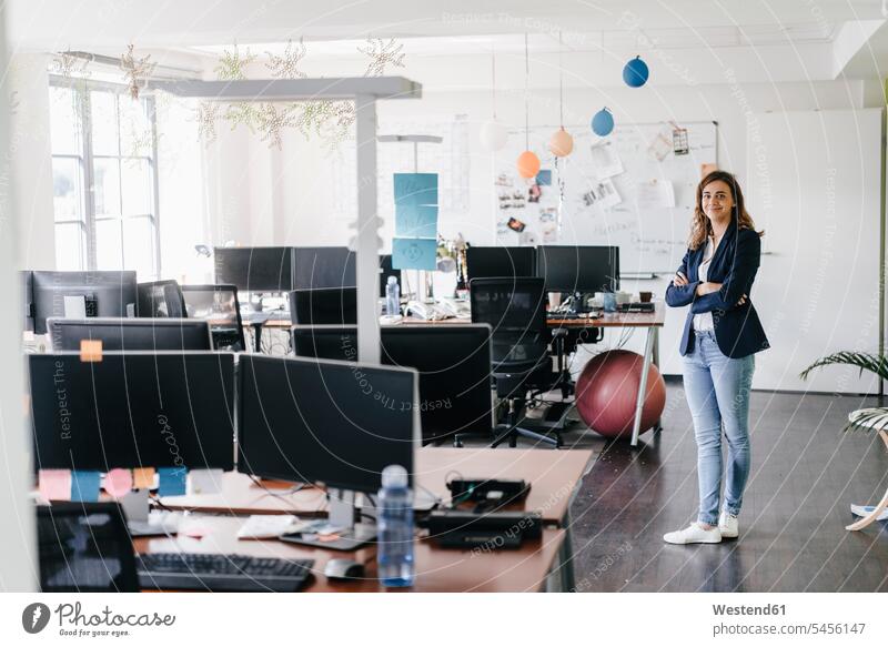 Confident businesswoman standing smiling in office smile confidence confident businesswomen business woman business women offices office room office rooms
