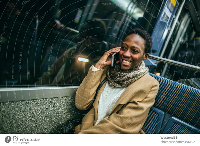 Portrait of smiling young woman on the phone in underground train portrait portraits call telephoning On The Telephone calling females women telephone call