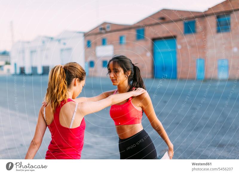 Two active women stretching and supporting each other exercise exercises practising exercising woman females female friends Adults grown-ups grownups adult