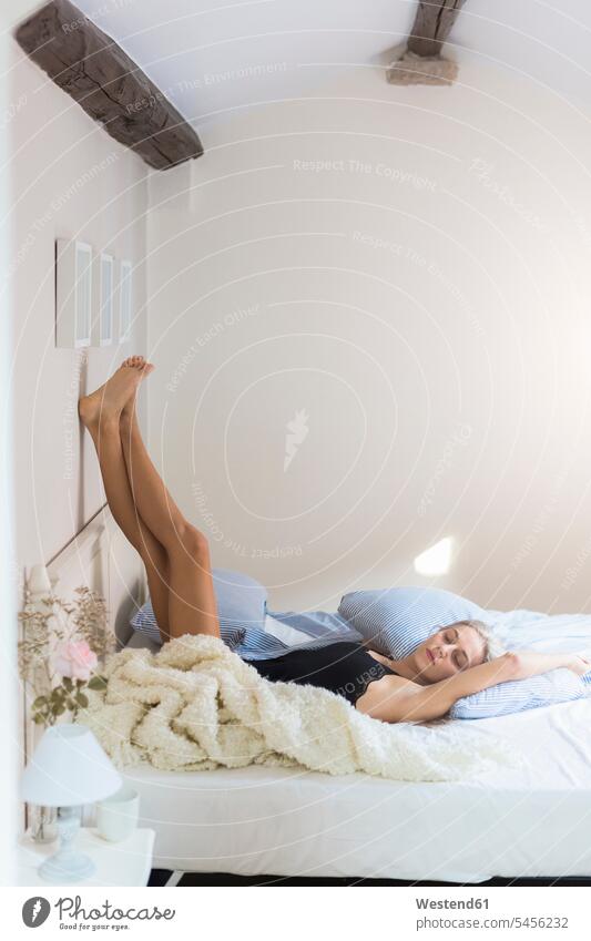 Daydreaming young woman in underwear lying on bed - a Royalty Free Stock  Photo from Photocase