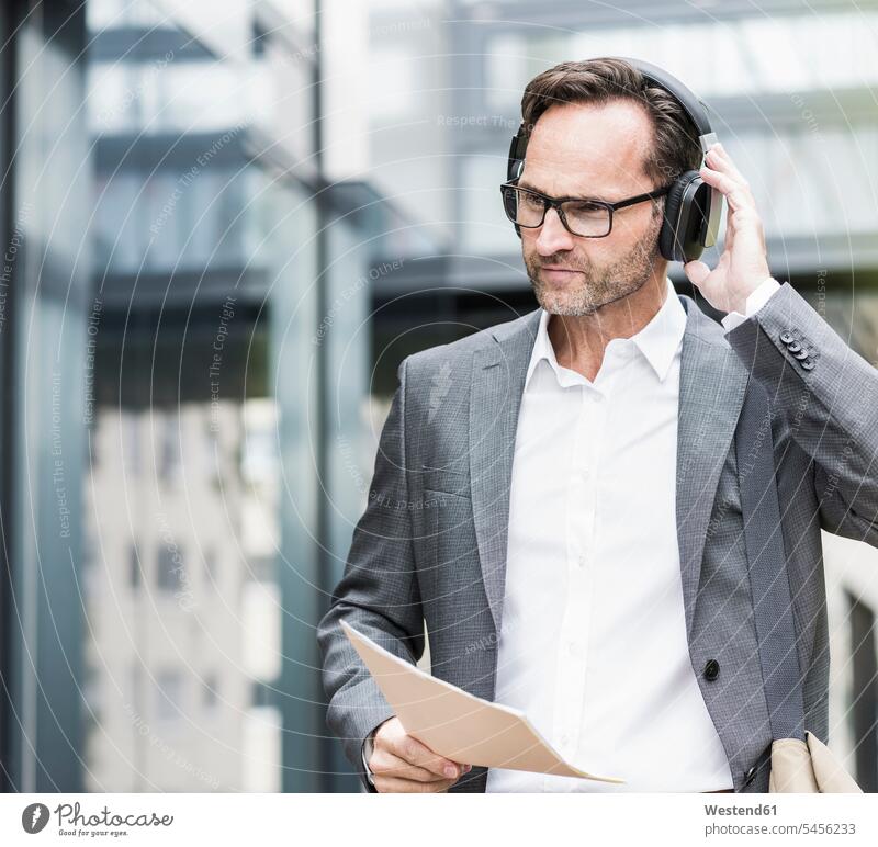 Portrait of businessman with documents and headphones Businessman Business man Businessmen Business men headset business people businesspeople business world