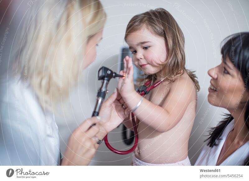Little girl at the pedeatrician playing with otoscope Auscultation auscultate auscultating stethoscope pediatrician paediatricians measuring measure measurement