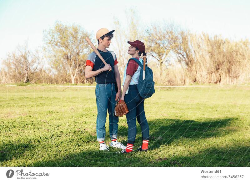 Young couple with baseball equipment in park baseball player baseball players twosomes partnership couples sport sports people persons human being humans