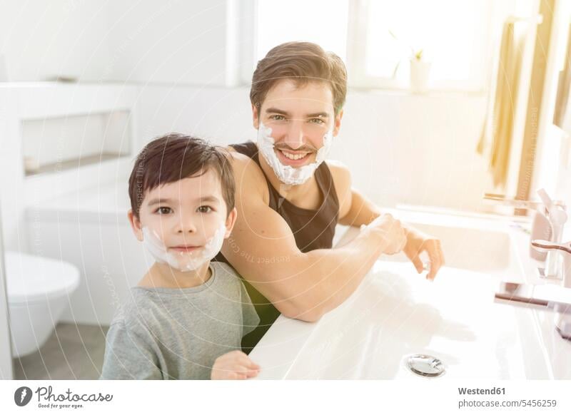 Portrait of father and son with shaving foam in their faces sons manchild manchildren applying smiling smile Fun having fun funny pa fathers daddy dads papa