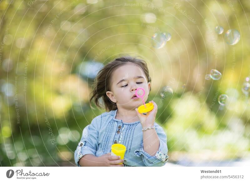 Girl blowing soap bubbles in park girl females girls parks child children kid kids people persons human being humans human beings day daylight shot