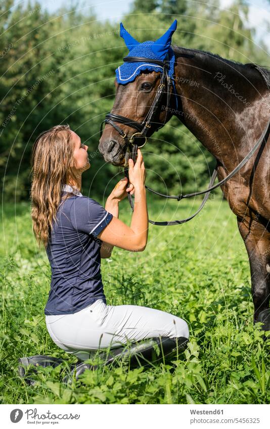 Young woman and horse on field riding horse riding ride equus caballus horses rider riders female rider horsewoman female rides horsewomen females mammal