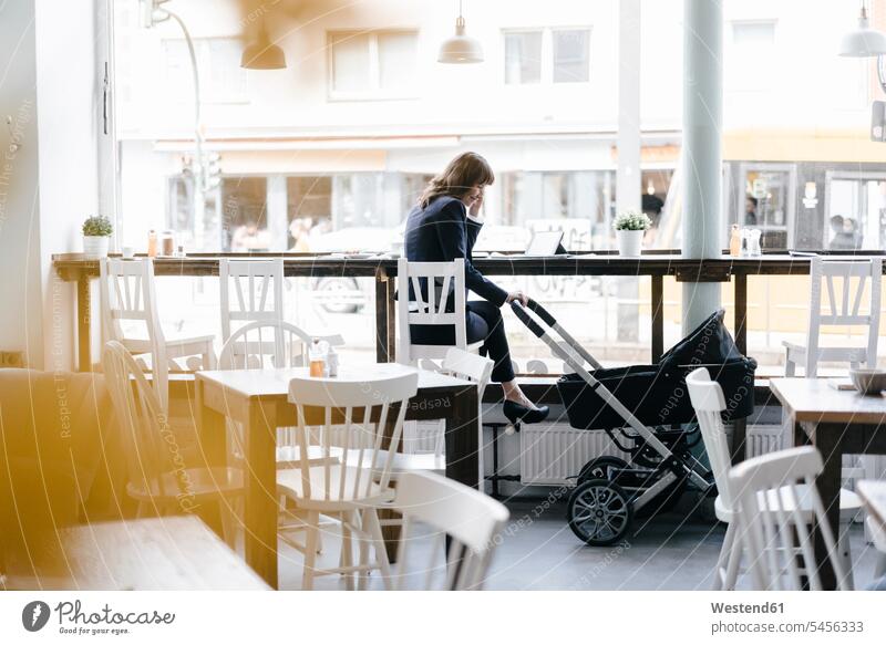 Businesswoman working from cafe with pram on her side mother mommy mothers mummy mama businesswoman businesswomen business woman business women At Work tablet