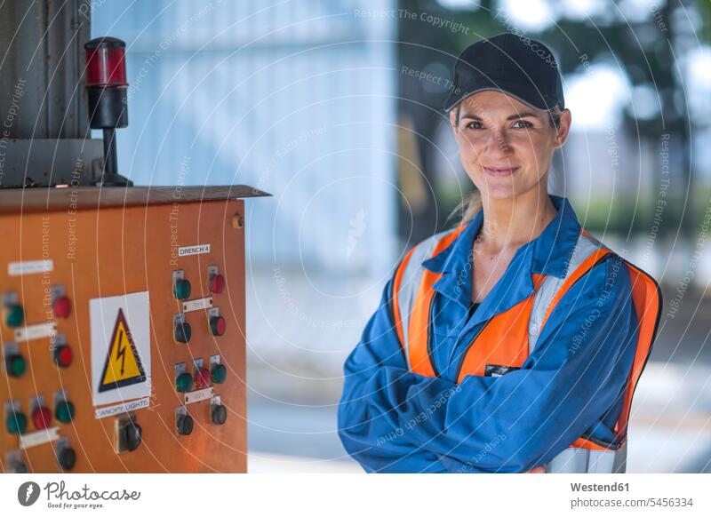 Portrait of confident woman wearing overalls and reflective jacket females women reflective vest reflector-vest reflector vest reflective vests portrait