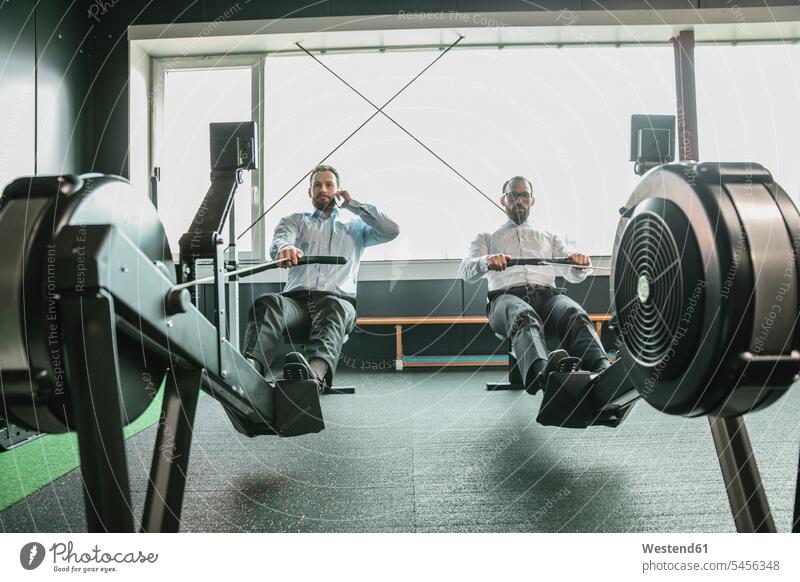 Businessmen training in gym, while making a phone call Smartphone iPhone Smartphones Sport Training Businessman Business man Business men on the phone